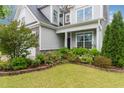 Charming home featuring a lush front yard with colorful flower beds, healthy shrubs, and a manicured lawn at 3904 Freemark Ln, Fuquay Varina, NC 27526