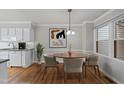 Cozy dining area features wood floors, stylish chandelier and view to the kitchen at 3940 Lake Ferry Dr, Raleigh, NC 27606