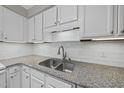 Kitchen detail showing stainless sink with granite countertops and white cabinets at 3940 Lake Ferry Dr, Raleigh, NC 27606