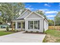 Charming home featuring black shutters, light gray siding, and a concrete driveway at 401 N Raiford St, Selma, NC 27576