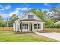Charming white cottage-style home with black shutters, wood columns, and well-manicured lawn at 405 N Raiford St, Selma, NC 27576