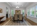 Sophisticated dining room featuring natural light, elegant chandelier, and decorative rug at 420 Creekhurst Pl, Cary, NC 27519
