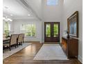 Bright dining room featuring hardwood floors, elegant lighting, and a view to the front yard at 420 Creekhurst Pl, Cary, NC 27519