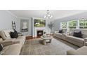 Cozy living room features a fireplace, TV, neutral furniture, hardwood floors, and ample natural light at 4621 Youngsbury Ct, Raleigh, NC 27604