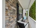 A cozy covered porch with stone accents, seating, and a white railing at 4621 Youngsbury Ct, Raleigh, NC 27604