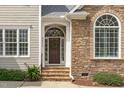 Elegant front door with stone surround, arched window, and inviting entrance steps at 5410 Highcroft Dr, Cary, NC 27519
