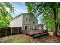 Spacious backyard featuring a wooden deck, fenced-in yard, and mature trees for privacy at 5410 Pageford Dr, Durham, NC 27703