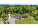 Charming single-story home with well-manicured lawn and detached garage nestled amongst mature trees at 553 Isley Rd, Haw River, NC 27258