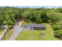 Aerial view of a single-story home with a large yard, mature trees, and detached garage at 553 Isley Rd, Haw River, NC 27258
