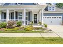 Inviting front porch with white columns, rocking chair, and well-manicured landscaping at 805 Narrative Ln, Durham, NC 27703