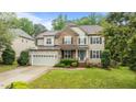 Attractive two-story home with stone and siding, a manicured lawn, and attached garage at 9013 Dansforeshire Way, Wake Forest, NC 27587