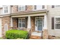 Cozy front porch featuring stone accents, black railings, and a seating area at 9013 Dansforeshire Way, Wake Forest, NC 27587
