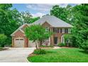 Traditional brick home showcasing a manicured front yard and lovely landscaping at 102 Lions Mouth Ct, Cary, NC 27518