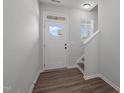 Bright foyer with wood-look floors and white door with windows at 1028 Gallivant Way, Wake Forest, NC 27587