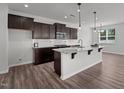 Modern kitchen featuring granite countertops, stainless steel appliances, and dark wood cabinets at 1028 Gallivant Way, Wake Forest, NC 27587