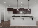 Stylish kitchen with a large center island, pendant lighting, and dark wood cabinets at 1028 Gallivant Way, Wake Forest, NC 27587