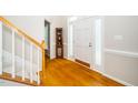 Welcoming foyer with hardwood floors, staircase, and decorative cabinet under natural light at 103 Chapelwood Way, Cary, NC 27518