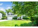 Two-story home featuring a manicured lawn, attached garage, and mature trees under blue skies at 103 Chapelwood Way, Cary, NC 27518