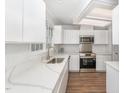 Well-lit kitchen with stainless steel appliances, white cabinets, and quartz countertops, creating a clean, modern look at 113 Spring Cove Dr, Cary, NC 27511