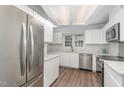 Bright kitchen with stainless steel appliances, modern white cabinets, light countertop and wood look floors at 113 Spring Cove Dr, Cary, NC 27511