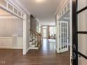 Elegant foyer featuring hardwood floors, staircase, and seamless transition into adjacent living spaces at 124 Creekvista Dr, Holly Springs, NC 27540