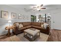 Spacious living area with a large sectional sofa, ottoman, stylish decor, and an open view to the adjacent kitchen at 1503 Laughridge Dr, Cary, NC 27511
