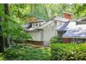 Stylish home exterior surrounded by lush greenery, showcasing unique architecture and a serene, wooded setting at 1604 Pinecrest Rd, Durham, NC 27705