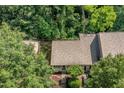 An aerial view of the home nestled in a tree-filled landscape showing the roof and front yard at 17 Crystal Oaks Ct, Durham, NC 27707