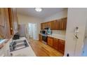 Functional kitchen with wooden cabinetry, stainless appliances, and hardwood flooring for easy maintenance at 20 Banbury Ct, Roxboro, NC 27573