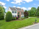 Charming two-story home featuring a brick and siding exterior, lush lawn, and mature landscaping at 2000 Katesbridge Ln, Raleigh, NC 27614