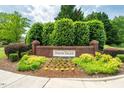 Welcoming entrance to Preston Village featuring lush greenery and a classic brick sign at 205 Benwell Ct, Cary, NC 27519