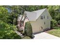 Home exterior featuring a two-car garage, lush landscaping, and a rear exterior brick accent wall at 205 Benwell Ct, Cary, NC 27519