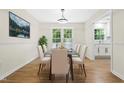 Bright dining room featuring a glass table, six chairs, natural light, and a seamless flow to the kitchen, ideal for gatherings at 214 Wax Myrtle Ct, Cary, NC 27513