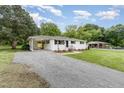 View of the well-maintained home with a carport and gravel driveway at 2205 W Carver St, Durham, NC 27705