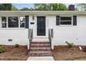 Inviting front entrance with brick steps and black door and shutters at 2205 W Carver St, Durham, NC 27705