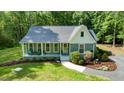 Inviting home with a quaint covered porch, manicured lawn, and lush surrounding greenery at 2409 New Hope Church Rd, Chapel Hill, NC 27514