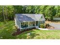 Charming home featuring a welcoming front porch, beautifully landscaped front yard, and a serene wooded backdrop at 2409 New Hope Church Rd, Chapel Hill, NC 27514