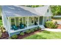 Charming home features a welcoming front porch and beautifully landscaped front yard with wooded backdrop at 2409 New Hope Church Rd, Chapel Hill, NC 27514