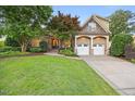 Charming home boasts a well-manicured lawn, stone accents, two car garage and mature trees, creating a welcoming curb appeal at 2507 Mayview Rd, Raleigh, NC 27607