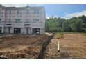New construction townhouse with visible framing, windows, and unfinished landscaping awaiting personalization at 252 Grand Silo Rd, Garner, NC 27603