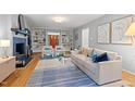 Open living room featuring hardwood floors, a comfortable sofa, a fireplace, and built-in shelving at 2525 Buxton Ct, Chapel Hill, NC 27514