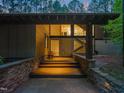 Modern home entrance with stone accents and illuminated wooden steps at 2721 Silver Stirrup Ln, Apex, NC 27502