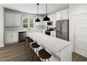 Modern kitchen features white cabinetry, stainless steel appliances, a large center island, and stylish pendant lighting at 340 Cottage Hill Way, Raleigh, NC 27604