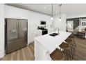Modern kitchen featuring stainless steel appliances, a spacious island with bar seating, and bright white cabinetry at 346 Cottage Hill Way, Raleigh, NC 27604