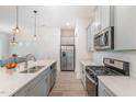 Modern kitchen with stainless steel appliances, quartz countertops and center island with bar stool seating at 362 Warm Wind Dr, Clayton, NC 27527
