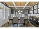 Beautiful dining room featuring coffered ceilings, elegant chandelier, and large windows for natural light at 3625 Bailey Lake Dr, Fuquay Varina, NC 27526
