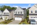 Charming two-story home featuring stone accents, a two-car garage, and manicured landscaping at 380 Garden Vine Trl, Raleigh, NC 27610