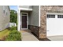Close-up of the home's front door with stone accents and manicured landscaping at 380 Garden Vine Trl, Raleigh, NC 27610