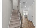 Carpeted staircase featuring a wooden handrail, leading to the upper level of the home at 380 Garden Vine Trl, Raleigh, NC 27610