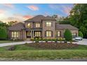 Beautiful brick home with a well-manicured lawn, elegant landscaping, and a circular driveway for stunning curb appeal at 3829 Westbury Lake Dr, Raleigh, NC 27603